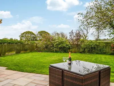a table with a bottle of wine and two glasses at Mount Farm - The Stable in Harker