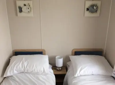 two beds sitting next to each other in a room at Lake District Western 2-Bed Cabin Pet Friendly in Wigton