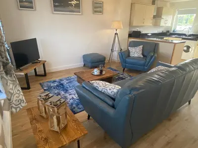 a living room with a couch and a table at Beachcomber in Garlieston