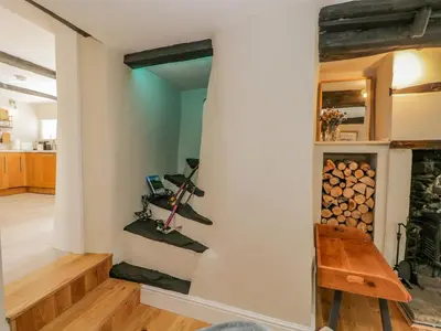 a stairway in a room with a stack of logs at Ashness in Keswick