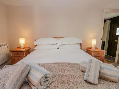 a bedroom with a bed with pillows and two lamps at Ashness in Keswick