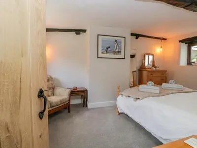 a bedroom with a bed and a chair at Ashness in Keswick
