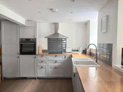 a kitchen with white cabinets and a stove top oven at Holiday House at 22, 3 bedroom cottage in historic Wigtown in Wigtown