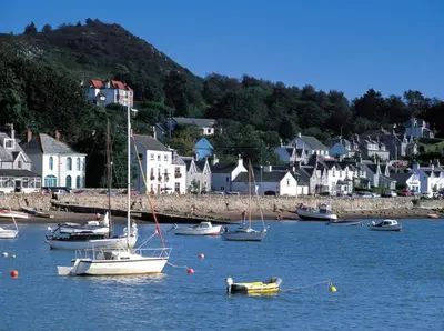 a group of boats in the water near a town at Coral Cabin in Kippford