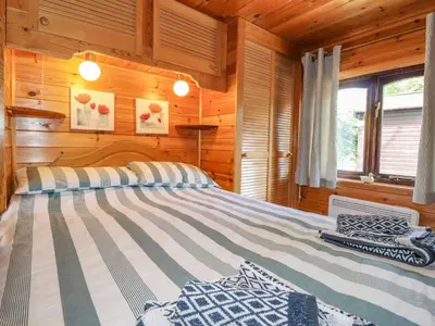 a bedroom with a bed in a log cabin at Robin's Nest in Keswick