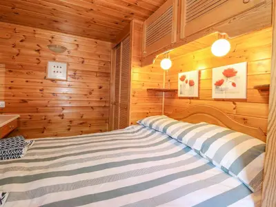 a bed in a room with wooden walls at Robin's Nest in Keswick