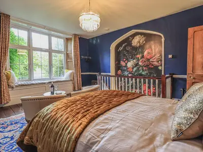 a bedroom with a large bed and a painting on the wall at Wisteria in Ambleside