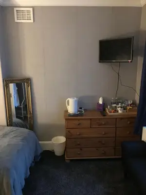 a bedroom with a bed and a dresser with a television at Dale View bed & breakfast in Holmrook