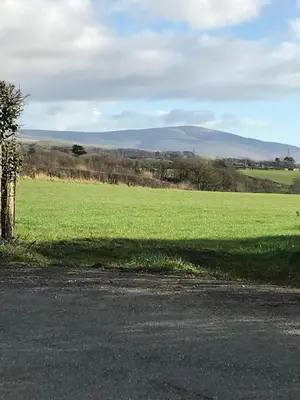 a field of green grass with a hill in the background at Dale View bed & breakfast in Holmrook