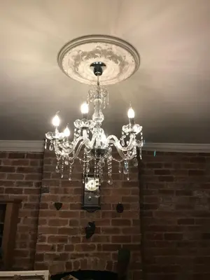 a chandelier hanging from a brick wall at Dale View bed & breakfast in Holmrook