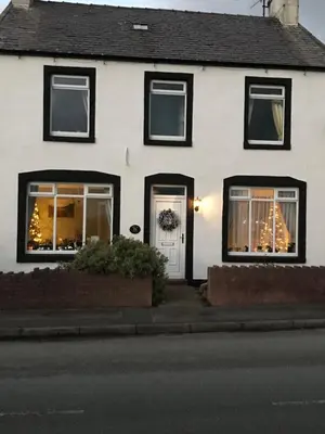 a white house with christmas lights in the windows at Dale View bed & breakfast in Holmrook