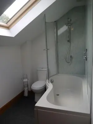 a bathroom with a shower and a toilet and a sink at Old Coach House in Moniaive