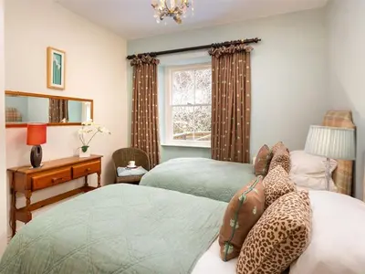 a bedroom with two beds with leopard pillows at Stone Beck in Ambleside