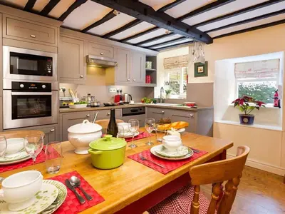 a kitchen with a wooden table with a dining room at Stone Beck in Ambleside