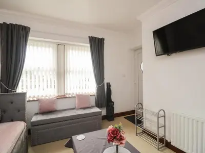 a living room with a couch and a tv at Shoreside Cottage in Wigton