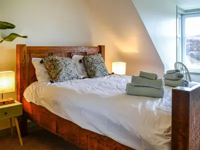 a bedroom with a bed with two pillows on it at 9A Church Place in Kirkcudbright