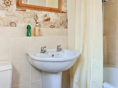 a bathroom with a sink and a toilet and a mirror at Craik Forestry Cottage in Teviothead