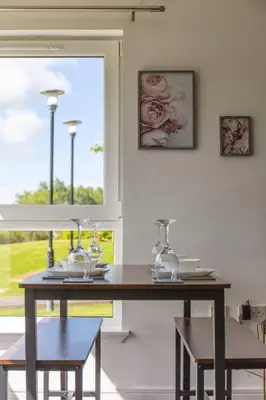 a dining room table with two chairs and a window at Walker Suite No 60 - Donnini Apartments in Kilmarnock