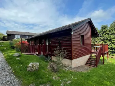 a small wooden cabin with a staircase in a yard at Beautiful 3BR Lodge - Stunning Beach and Golf Location - Pass the Keys in Dalbeattie