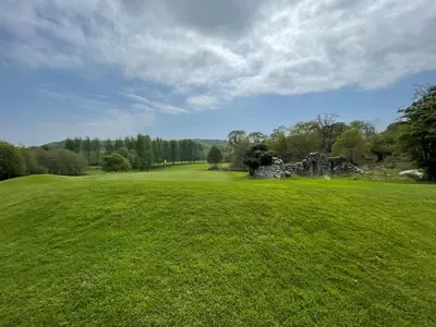 an old stone building in a green field at Beautiful 3BR Lodge - Stunning Beach and Golf Location - Pass the Keys in Dalbeattie