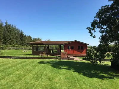 a cabin in a field with a grass yard at Gamepark Wood Holiday Cottage in Castle Douglas