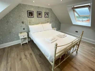 a bedroom with a bed with white sheets and a window at Beautifully Presented 3BR Luxury Apartment - Pass the Keys in Kirkcudbright