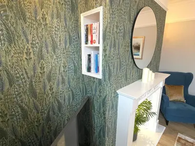 a hallway with a mirror and a blue couch at Beautifully Presented 3BR Luxury Apartment - Pass the Keys in Kirkcudbright