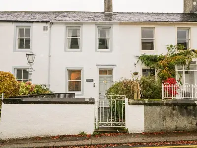 a white house with a gate in front of it at Raphael's Cottage in Keswick