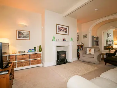 a living room with a fireplace and a tv at Raphael's Cottage in Keswick