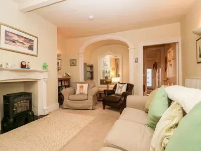 a living room with a couch and a fireplace at Raphael's Cottage in Keswick