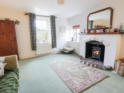 a living room with a fireplace and a mirror at Strathannan in Moffat