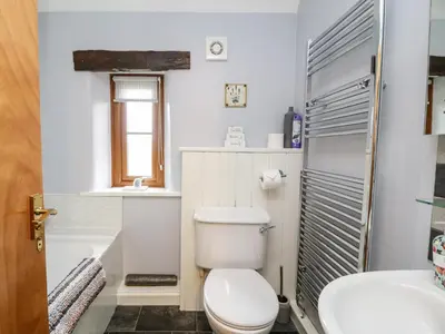 a bathroom with a toilet and a sink and a tub at Lavender Cottage in Penrith