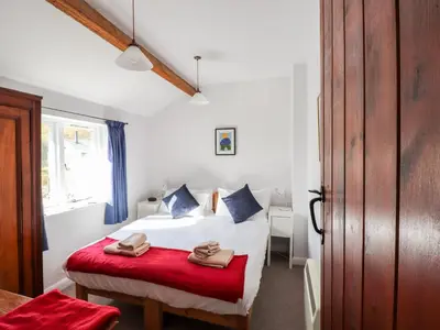a bedroom with a bed and a red bench at One Town End in Penrith