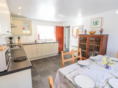 a kitchen with a table with chairs and a kitchen with a counter at One Town End in Penrith