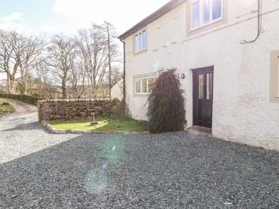 a house with a gravel driveway in front of it at One Town End in Penrith