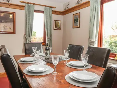 a dining room with a wooden table and chairs at Beech Nook in Keswick