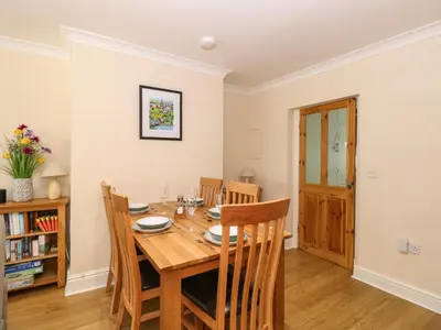 a dining room with a wooden table and chairs at Inglewood in Keswick