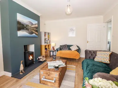 a living room with a couch and a fireplace at Pooley Howe in Keswick
