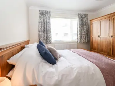 a bedroom with a bed with blue pillows and a window at Pooley Howe in Keswick