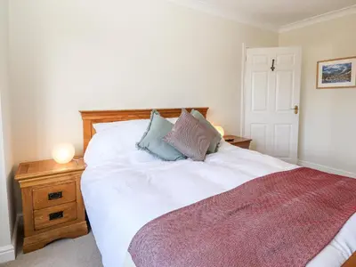 a bedroom with a white bed with two pillows on it at Pooley Howe in Keswick