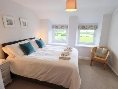 a bedroom with a large bed with towels on it at Squirrel Cottage in Keswick