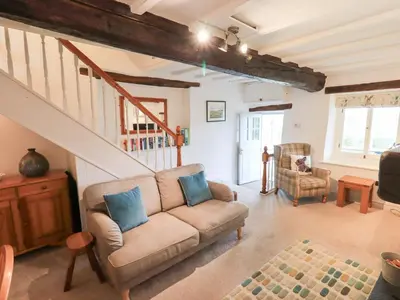 a living room with a couch and a staircase at Squirrel Cottage in Keswick