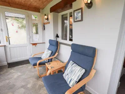 two blue chairs and a table in a room at Squirrel Cottage in Keswick