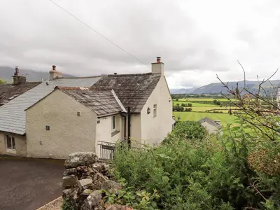 a white house with a view of a field at Squirrel Cottage in Keswick
