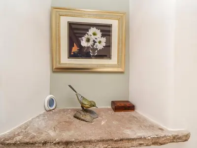 a bird statue sitting on a table under a picture at Daisy Cottage in Penrith