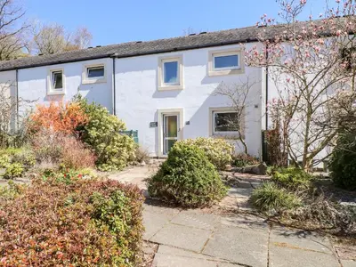 a white house with a garden in front of it at Annes Cottage in Keswick