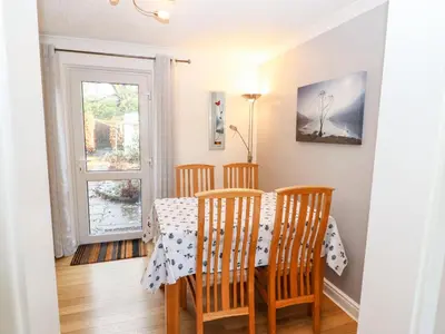 a dining room with a table and chairs and a window at Annes Cottage in Keswick