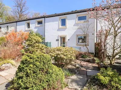 a white house with bushes in front of it at Annes Cottage in Keswick