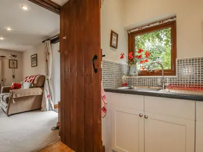 a kitchen with a sink and a window at Poppy Cottage in Penrith