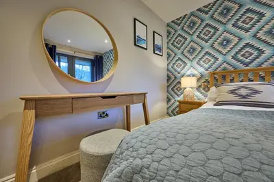a bedroom with a large mirror and a bed at Riverside Park 5 in Keswick